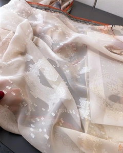 Detail of translucent cream floral silk scarf featuring vintage prints and jacquard texture
