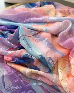 Close-up of printed floral silk scarf showing jacquard dot texture and colorful abstract pattern