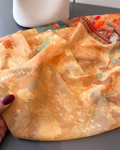 Detail of orange floral silk shawl showing delicate jacquard texture and ethnic border