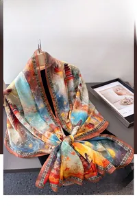 Détail d'un foulard en soie léger avec imprimé paysage artistique en bleu et orange