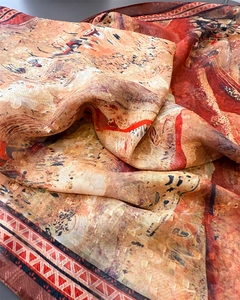 Texture détaillée de l'écharpe légère en soie avec motifs abstraits et tons orange