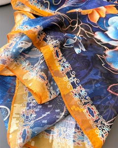 Détail d'une écharpe en soie légère avec motifs floraux orange et bleu de haute qualité