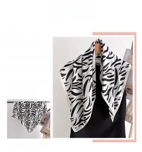 Detail of classic black and white zebra print silk scarf draped on a dark garment