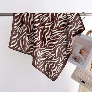 Close-up of zebra print silk scarf in dark brown and white on a minimalist display