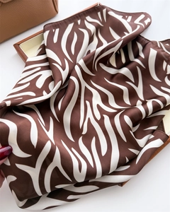 Detailed macro view of zebra print silk scarf with luxury smooth satin texture and sheen