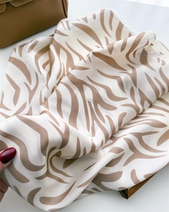 Detailed close-up of premium silk scarf featuring elegant brown zebra animal print pattern