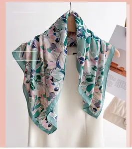 Detail of printed silk scarf with abstract floral pattern hanging on a wooden hanger