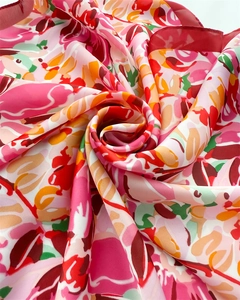 Macro view of silky floral scarf with artistic abstract patterns and fine red hem stitch