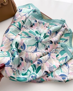 Detailed close-up of floral print silk scarf with mint green borders and soft luster
