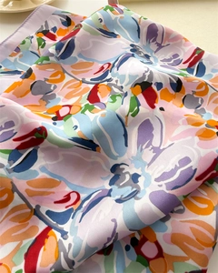 Detailed view of colorful floral print silk scarf with refined edge stitching quality