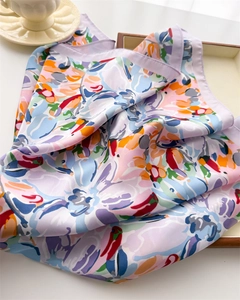 Close-up of floral silk scarf with artistic print on minimalist tray with cup