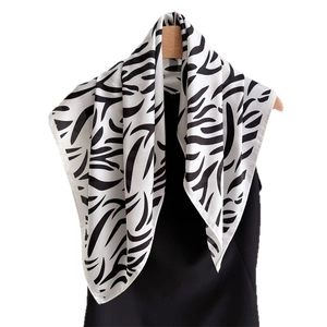 Classic black and white zebra print silk scarf hanging on a wooden hanger with satin finish