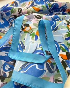 Detail of floral silk scarf showing fine stitching and vibrant blue border texture