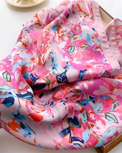 Macro detail of silky satin scarf showing floral patterns and smooth glossy texture