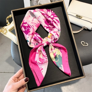 Detail of floral silk scarf tied in a bow showing purple satin texture and soft drape