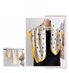 Vue détaillée du foulard en soie à imprimé fleuri avec ourlet jaune et motif camélia