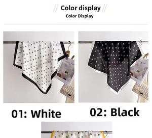 Présentation d'écharpes en soie à fleurs en blanc et noir sur un support en métal