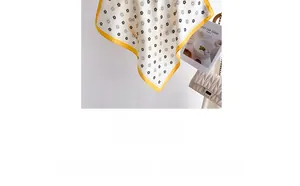 Détail d'un foulard en soie à fleurs crème et jaune avec un sac à bandoulière matelassé chic