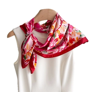 Floral print silk scarf with vibrant red flower patterns on a white hanger and dress