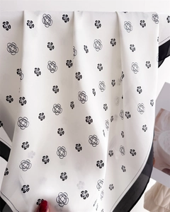 Détail d'un foulard en soie avec motif camélia et texture satinée lisse