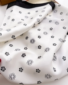 Gros plan détaillé d'un foulard en soie haut de gamme avec imprimé floral camélia noir et blanc