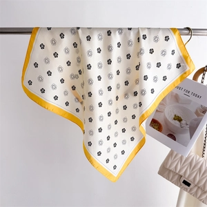 Détail d'un carré de soie floral suspendu avec un sac matelassé et un magazine