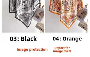 Detail of printed silk scarves in orange and black with paisley patterns and soft texture