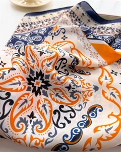 Close-up of paisley silk scarf with orange and blue patterns showing smooth fabric texture
