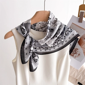 Elegant paisley print silk scarf in black white and gray knotted on a wooden hanger