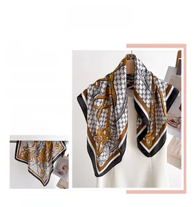 Detailed view of large silk square scarf featuring equestrian chain and buckle pattern