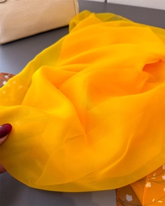 Macro detail of breathable bright yellow lightweight chiffon scarf showing sheer texture