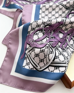 Macro shot of silk square scarf featuring equestrian horsebit patterns and UR monogram
