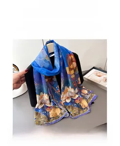 Detailed view of royal blue silk scarf featuring elegant floral lotus and classical patterns