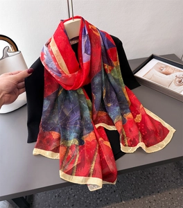 Detailed view of vibrant floral print silk scarf with fine rolled edges and smooth texture