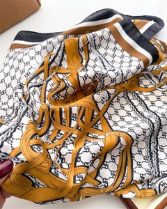 Close-up of silk scarf showing vintage JR print with golden chains and smooth texture