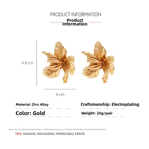 Macro view of gold flower earrings with polished petal texture and size measurements