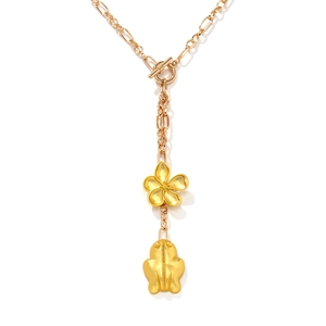 Collier en Y doré vintage avec pendentifs fleur et papillon sur fond blanc pur