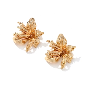 Detailed close-up of golden 3D flower earrings showing realistic petal texture and metal finish