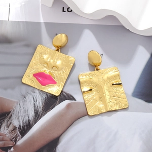 Vintage gold square face earrings with abstract facial features and pink lip accents