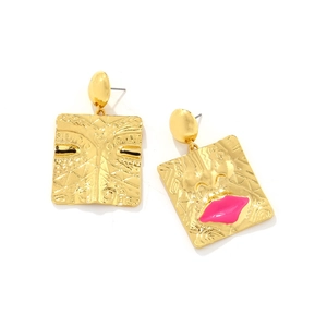 Detailed view of gold square drop earrings featuring abstract face and pink enamel lips