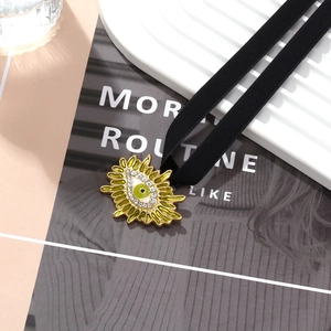 Choker vintage avec pendentif soleil doré, émail vert et strass brillants sur velours