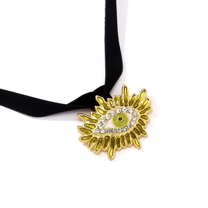 Gros plan du collier choker œil maléfique doré avec émail émeraude et strass brillants