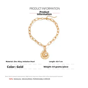 Detail of gold seashell pendant necklace with white pearls and chunky link chain