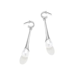 Détail de longues boucles d'oreilles argentées avec métal poli et perles en goutte