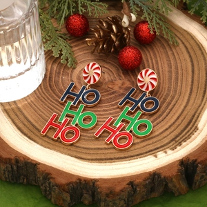 Détail de boucles d'oreilles de Noël avec texte HO HO HO et clous en forme de sucre