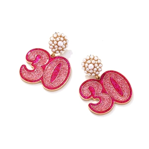 Détail de boucles d'oreilles numéro 30 avec paillettes roses et clous en perles