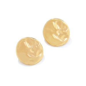 Detailed view of round gold earrings featuring a textured hammered metal surface design