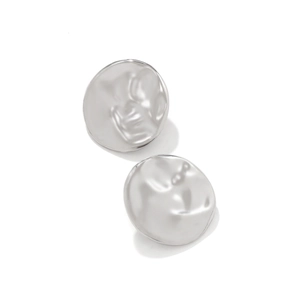 Macro detail of silver geometric earrings with hammered relief texture and wavy surface