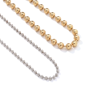 Détail de colliers multi-rangs à billes dorées et argentées avec texture métallique lisse