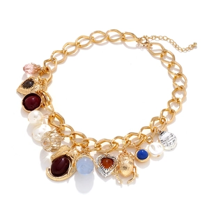 Vintage Goldkette mit Herz, Insekt und Perlenanhängern auf weißem Hintergrund